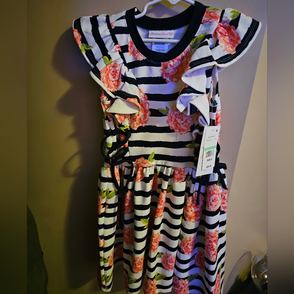 Girls ruffle dress with tie sides.